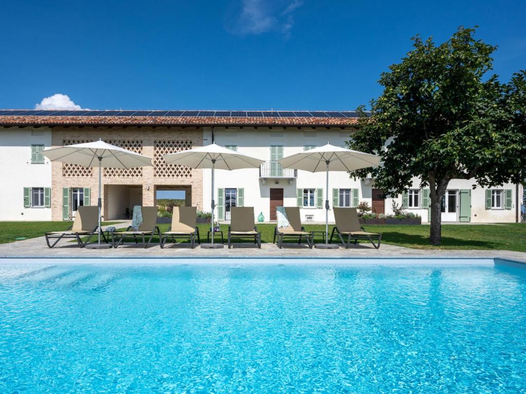 科斯蒂廖莱达斯蒂Holiday Home Casa Faretto - Monviso & Collina by Interhome的房屋前的带椅子和遮阳伞的游泳池