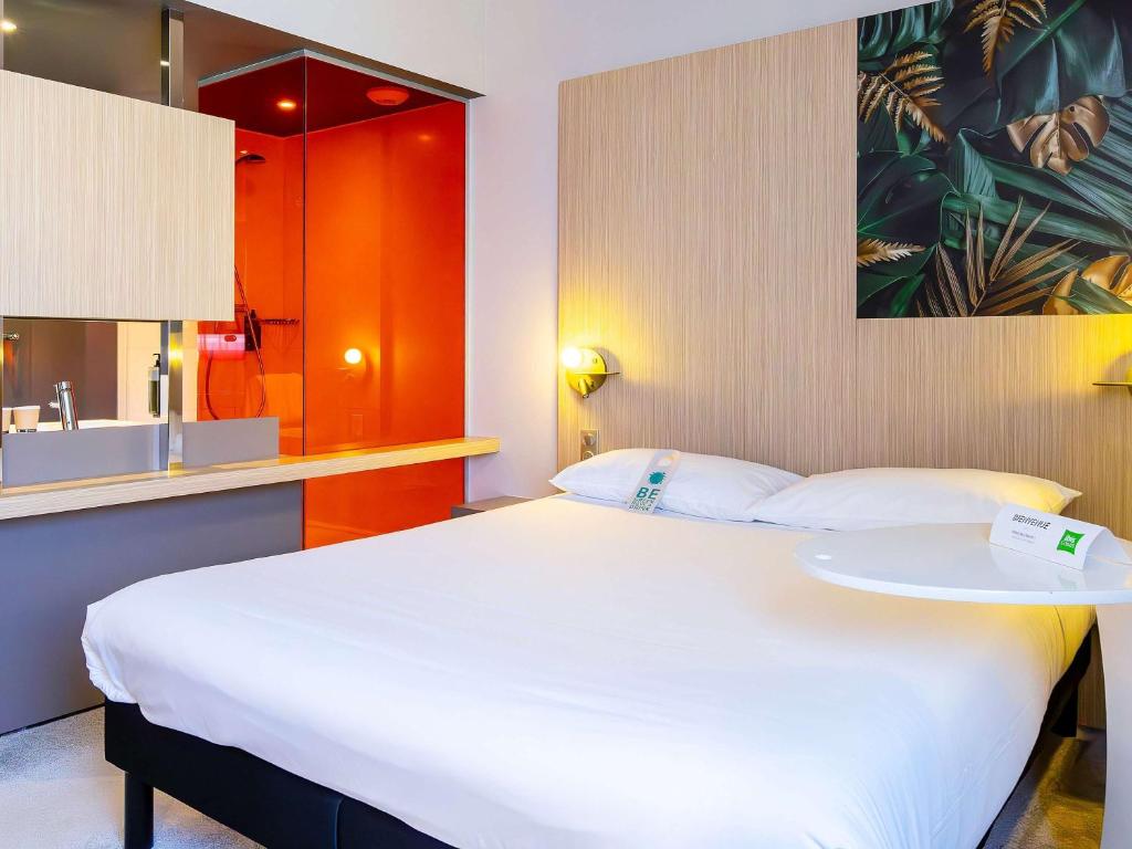 特鲁瓦ibis Styles Troyes Centre的卧室配有一张白色的大床和一张桌子