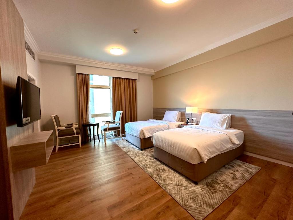 麦纳麦MIRADOR HOTEL的酒店客房设有两张床和一台平面电视。