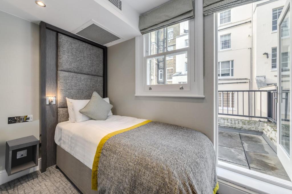 伦敦伦敦维多利亚莫宁顿酒店的一间卧室设有一张床和一个大窗户