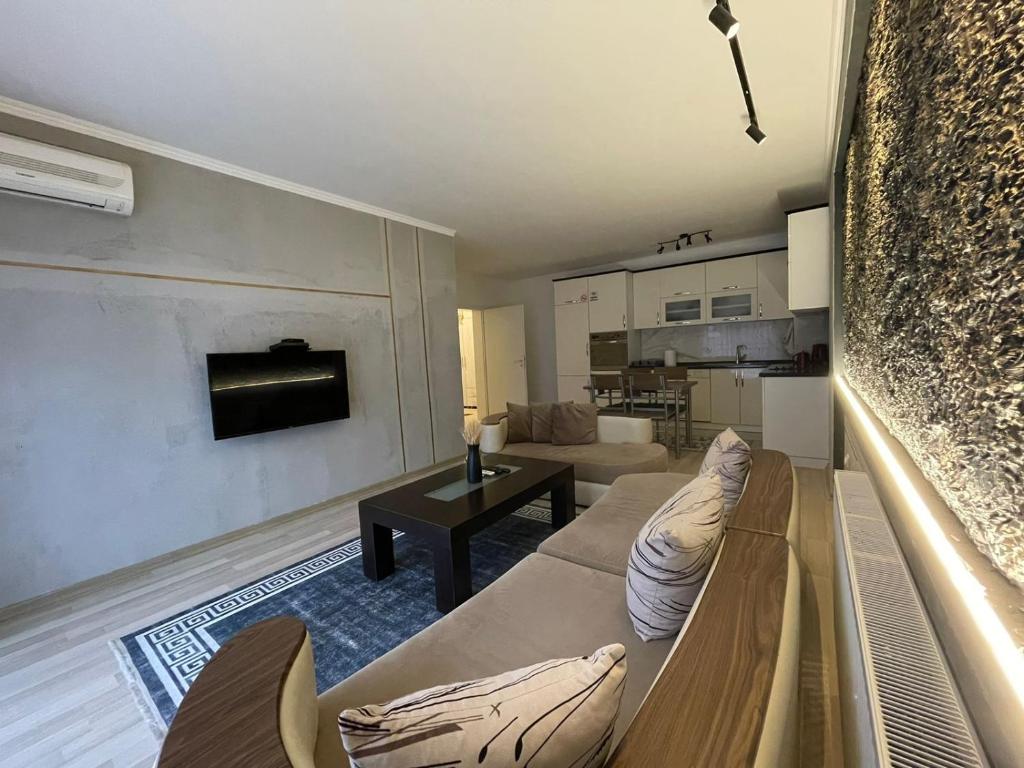 普里什蒂纳Daily Apartment Prishtina的客厅配有沙发和桌子