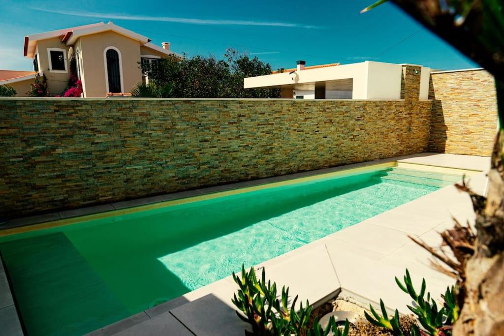 帕塔亚什Casa da Brisa do Mar的砖墙前的游泳池