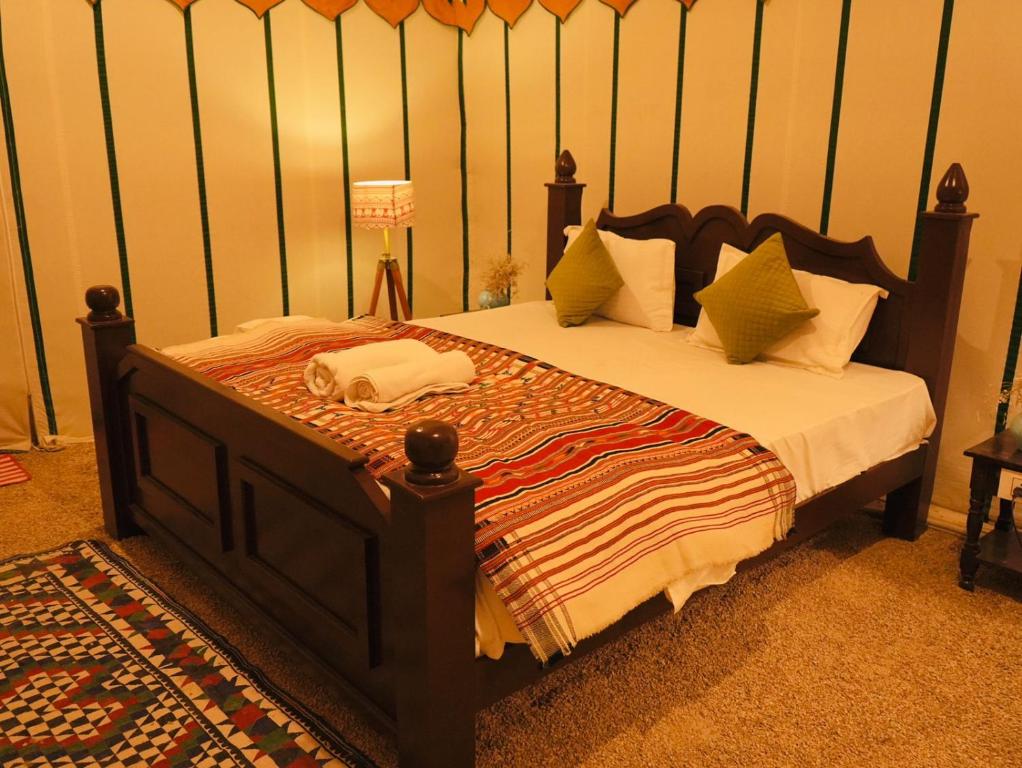山姆Venture Desert Camp Jaisalmer的一间卧室配有一张大床和木制床头板