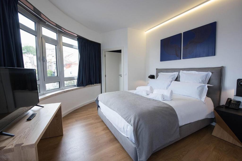 里斯本room00 Lisboa Hostel的一间卧室配有一张大床和一台平面电视