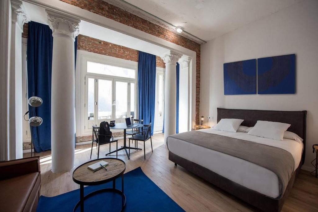 马德里room00 Gran Vía Hostel的一间卧室配有一张床、一张桌子和一张书桌
