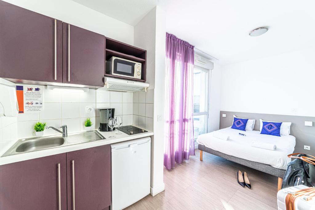马赛蒙特姆珀马赛中心欧洲地中海公寓式酒店的一个带水槽的厨房和一张位于客房内的床