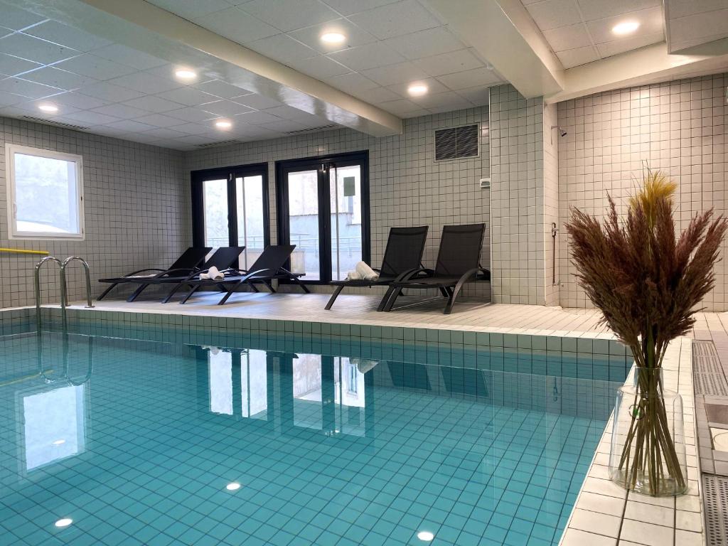 南希Nemea Appart Hotel Home Suite Nancy Centre的一座游泳池,四周摆放着椅子