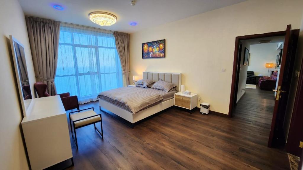 阿吉曼Ocean View Luxury Suites的卧室配有床、椅子和窗户。
