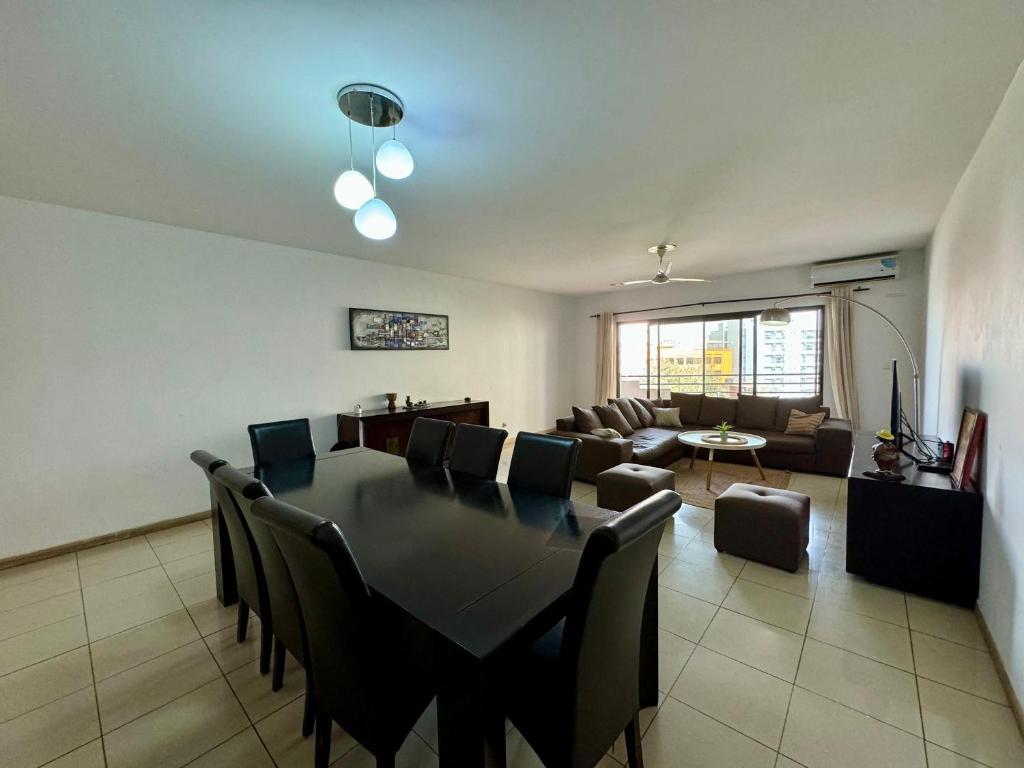 达喀尔Mansa home的用餐室以及带桌椅的起居室。