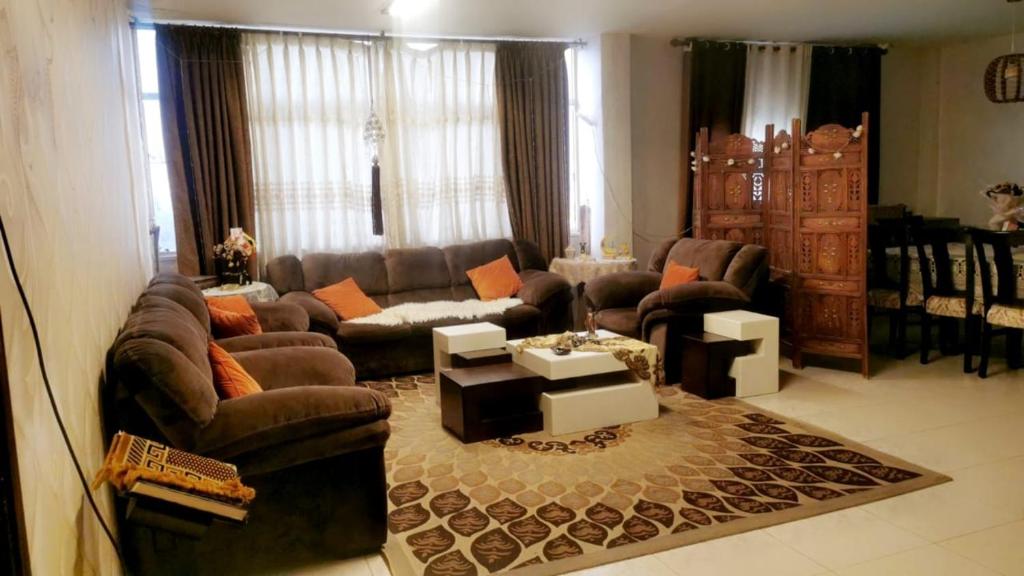 Jordanian family hosting的客厅配有沙发和桌子