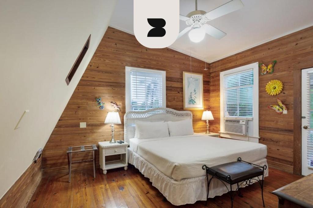 基韦斯特Curry House by Brightwild- 3rd Floor, King Bed, & Balcony Room 8的卧室设有白色的床和木墙