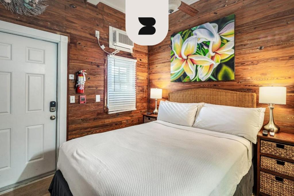 基韦斯特Coral Cove #1 by Brightwild的卧室设有白色的床和木墙