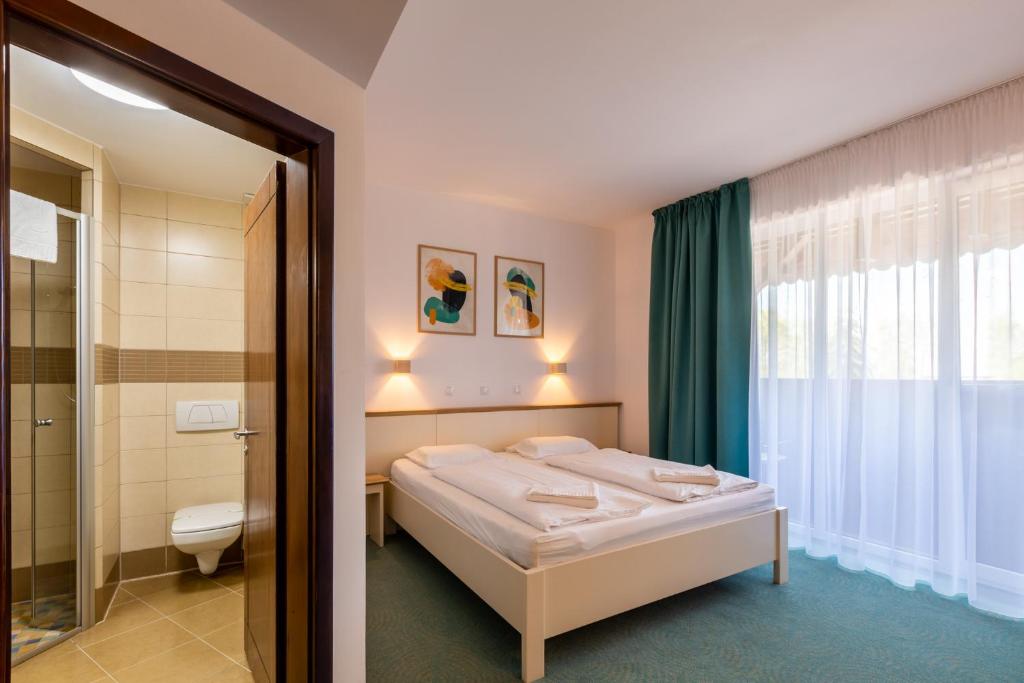 Arpaşu de Sus帕斯特拉瓦利亚阿伯塔度假村的一间带床的小卧室和一间浴室