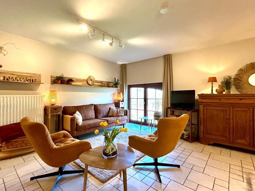 EllezellesAu Coeur Des Collines, Chouette的客厅配有沙发、椅子和桌子