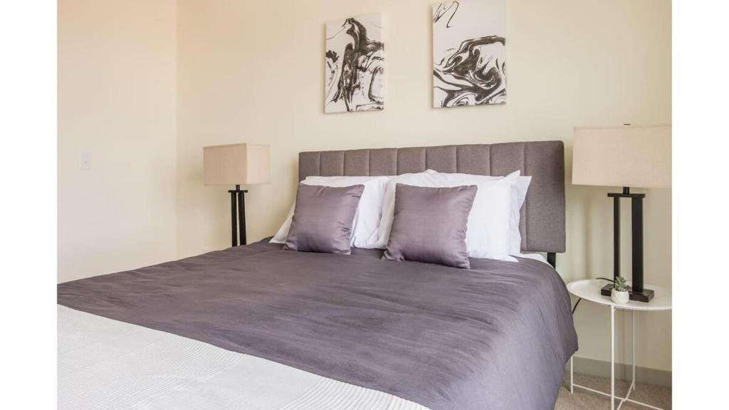 路易斯威尔Stunning Nulu 1BR CozySuites Unit 03的一间卧室配有一张大床,提供紫色床单和枕头