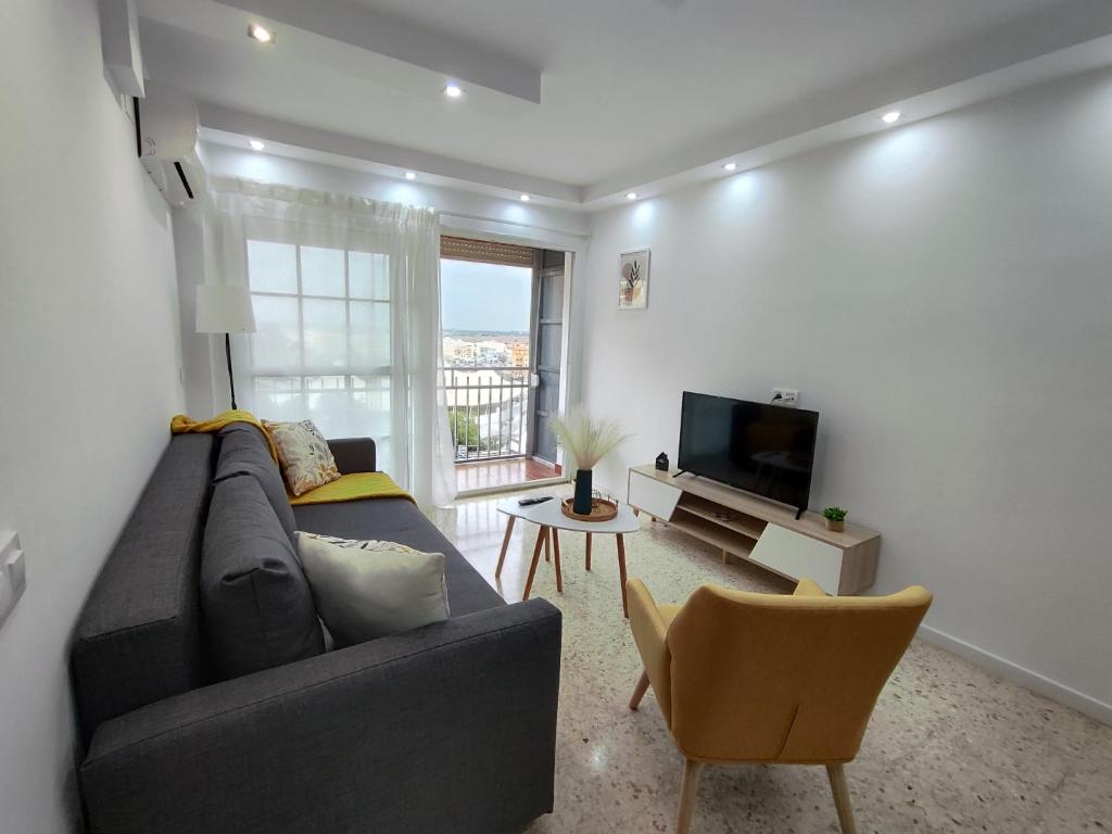 卡马斯Precioso apartamento en Sevilla.的带沙发和电视的客厅