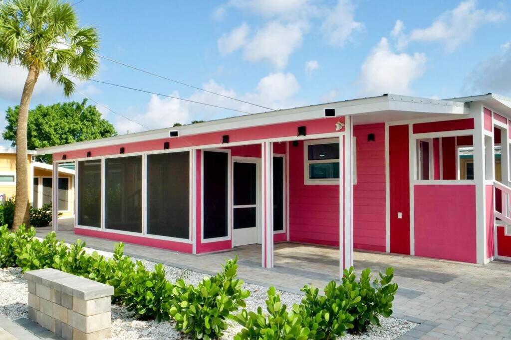 萨拉索塔Sunrise Tiny Home - New&Cozy的一座粉红色的房子,前面有一棵棕榈树