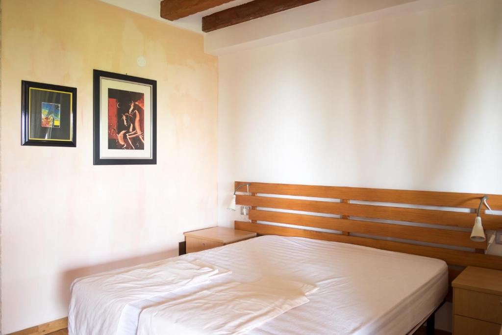 MontechiarugoloPrivate Room close to Beautiful Parma的卧室配有一张床,墙上挂有两张照片