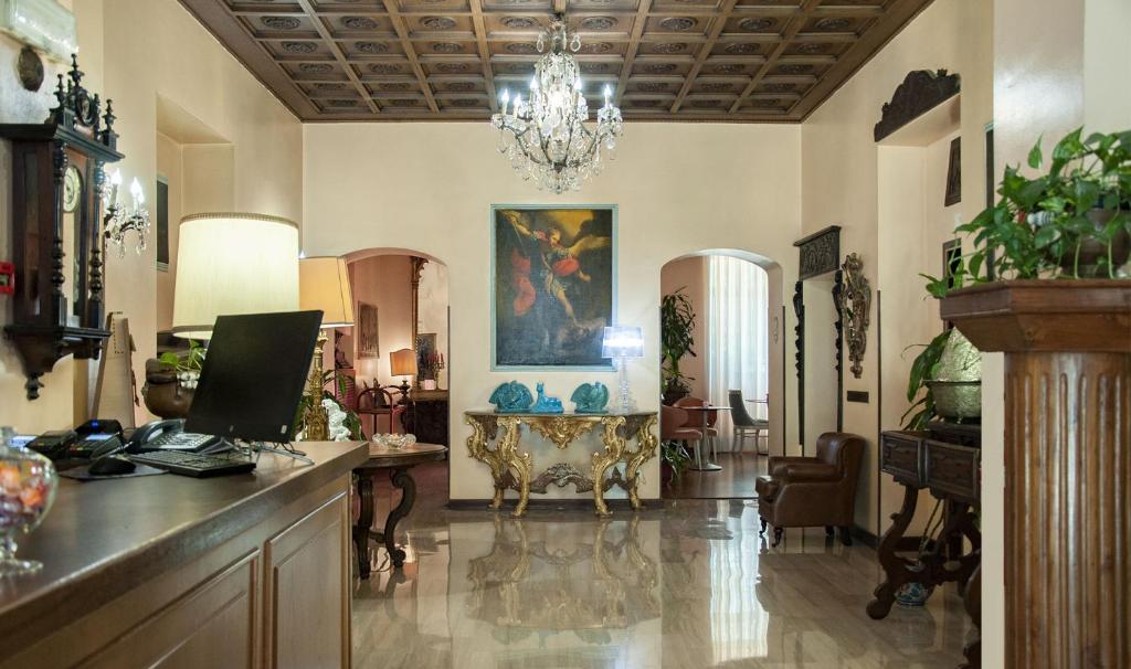 米兰圣桂多酒店的一个带桌子和吊灯的大客厅