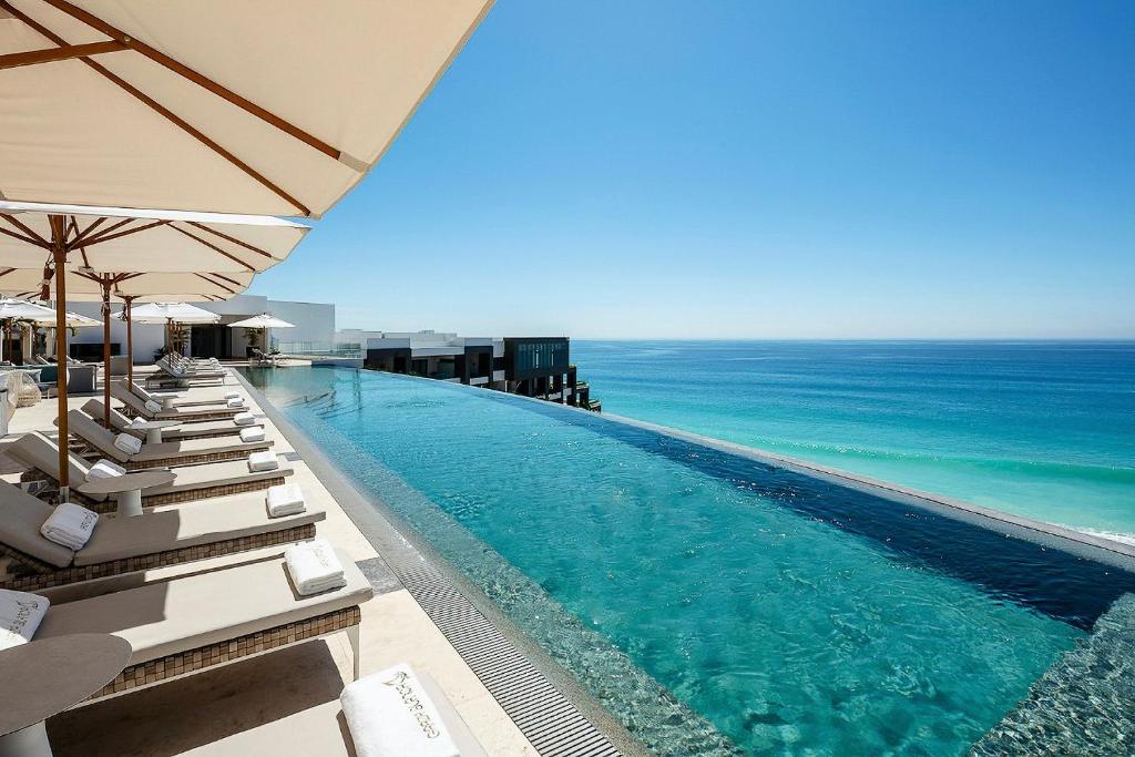卡波圣卢卡斯Residential Retreat 3 Bedroom Suite Ocean Front Garza Blanca Los Cabos Resort & Spa的一个带躺椅的游泳池和海洋