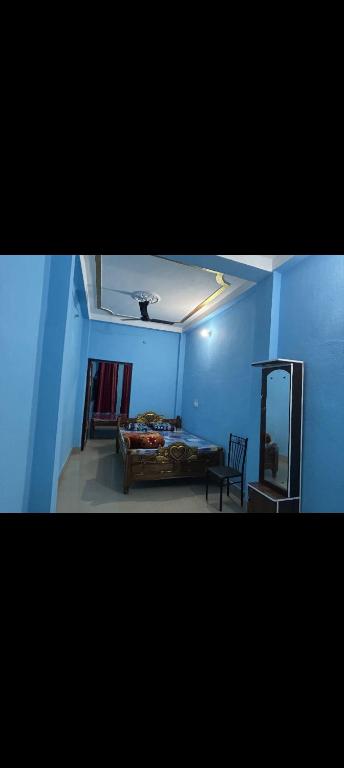 德奥加尔MAA MANSHA GUEST HOUSE的蓝色的客房配有床和镜子
