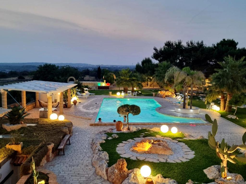 莱乌卡Villa Liquattruvienti的一个带灯光的室外游泳池以及度假村