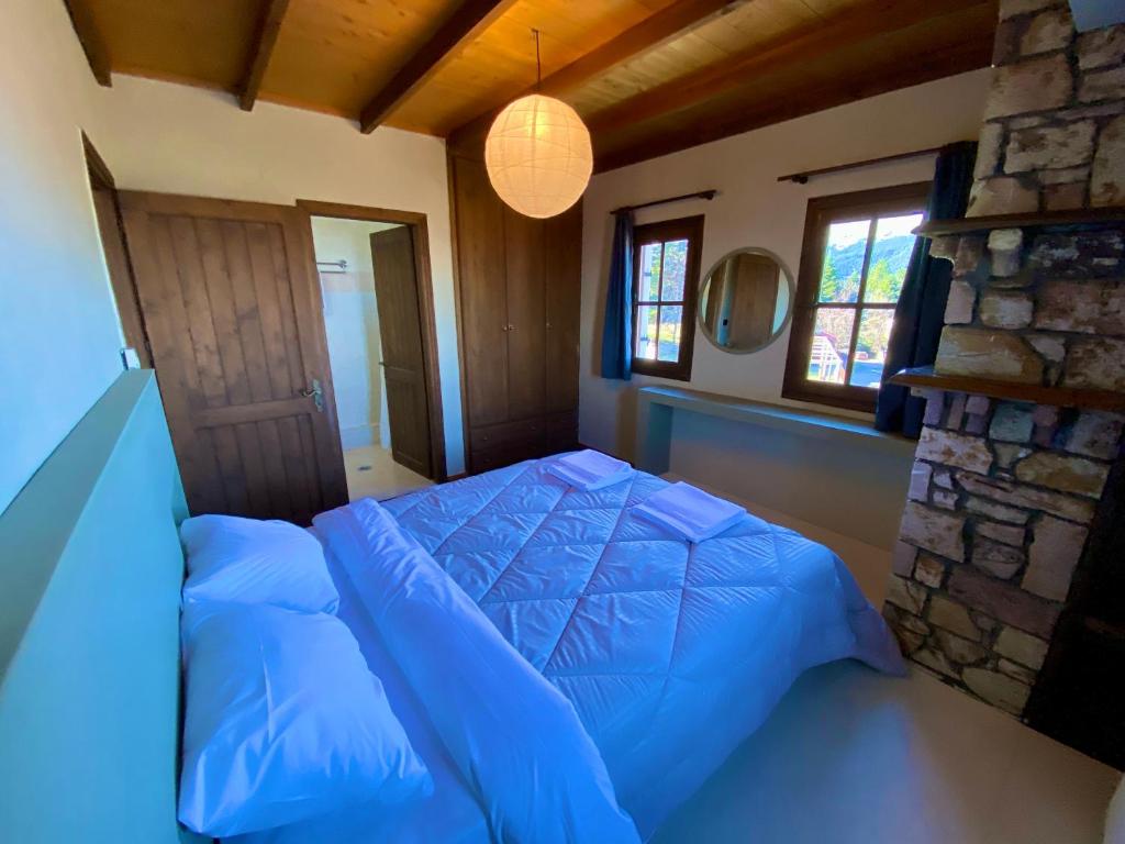 讷瑞达Σκίουρος的一间卧室设有蓝色的床和石墙