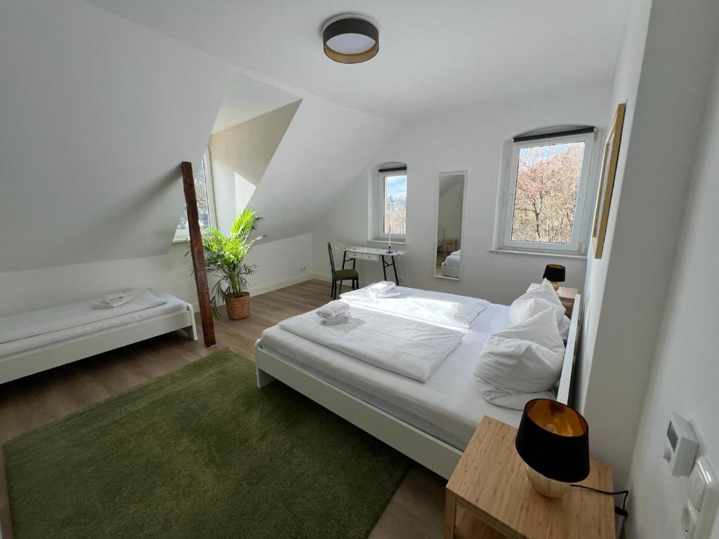 库姆巴赫Villa Plassenburg的白色卧室配有床和桌子