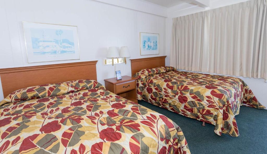 大洋城Fish Tales Boardwalk Inn &amp; Ocean Mecca Motel的一间酒店客房,房间内设有两张床
