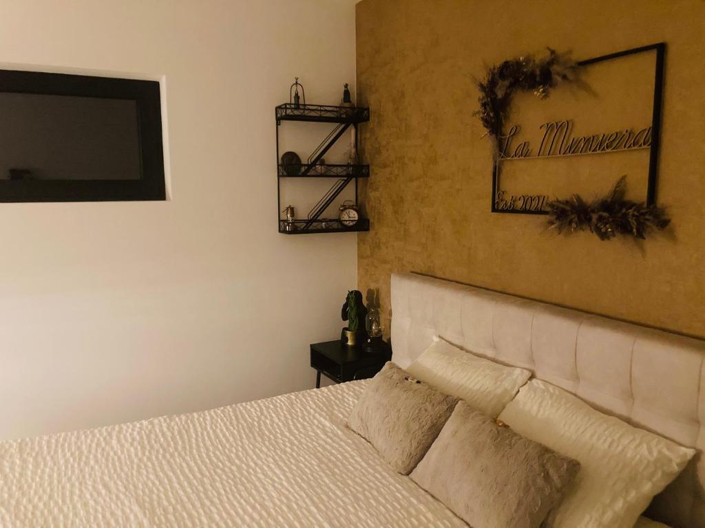亨克B&B La Miniera的卧室配有一张床,墙上配有电视。