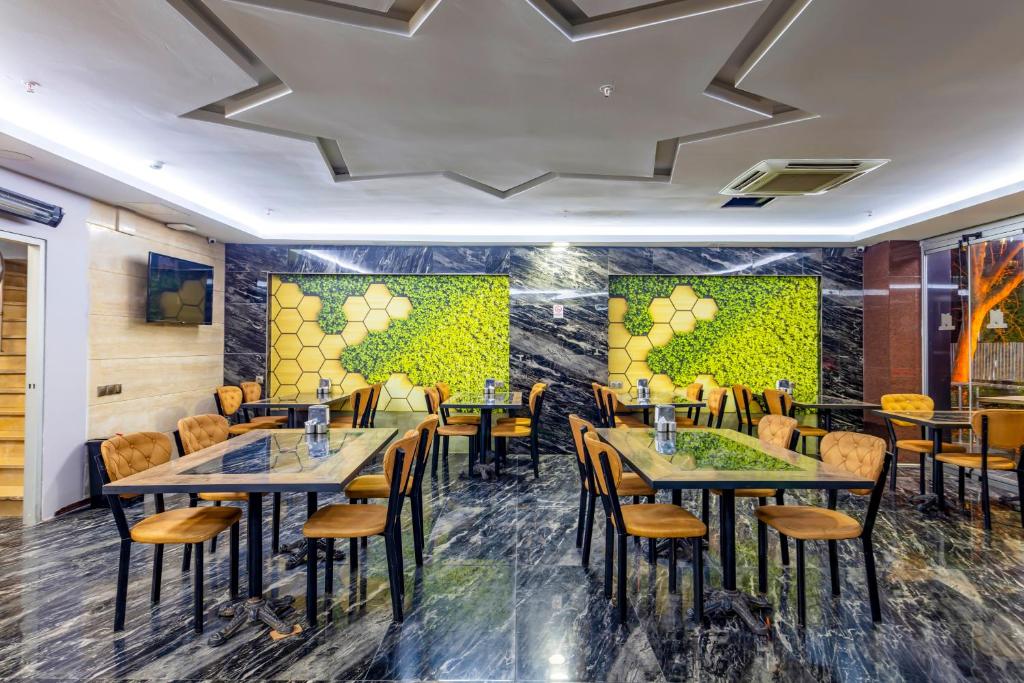 伊斯坦布尔Dem İstanbul Airport Hotel的一间在房间内配有桌椅的餐厅
