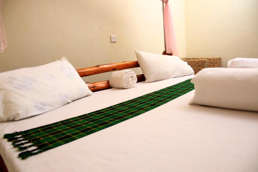 KapchorwaSipi Guest House的一间卧室配有两张带白色和绿色床单的床