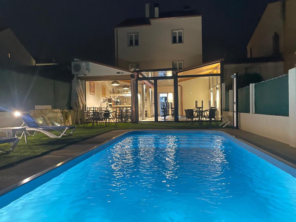 梅利德Pension San Anton的夜间游泳池与房子