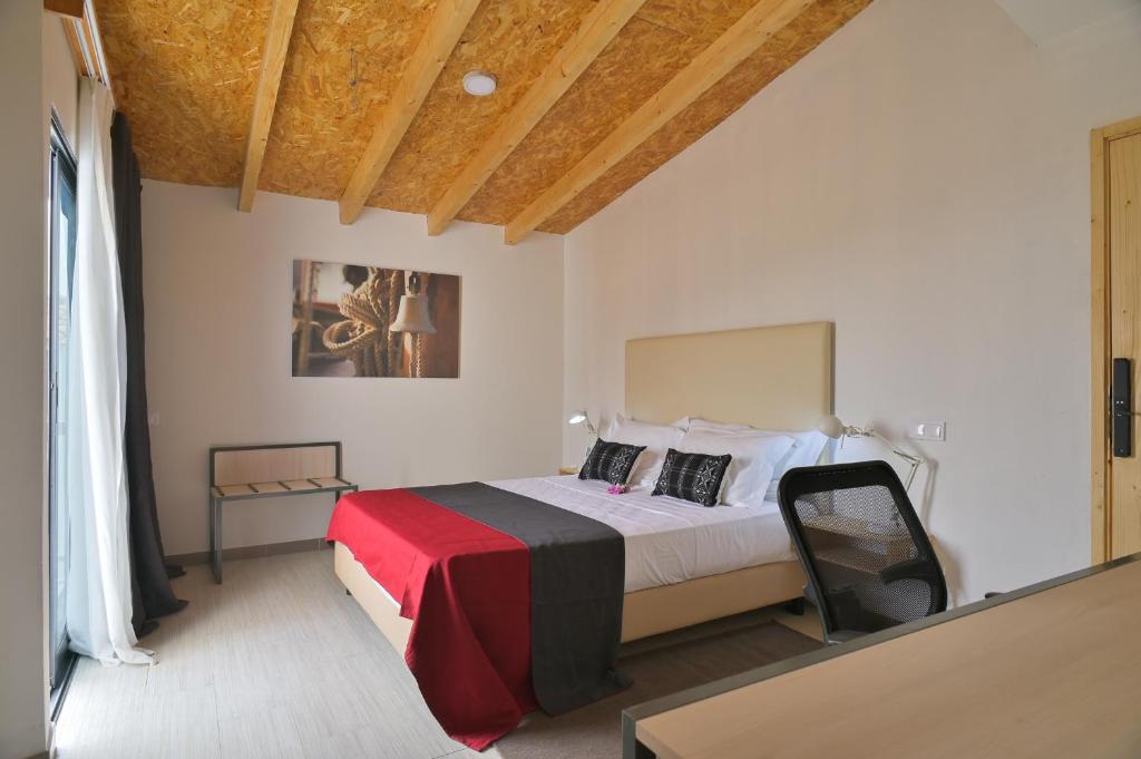 Cidade VelhaEncosta Azul Guesthouse的一间卧室配有一张带红色和黑色毯子的床