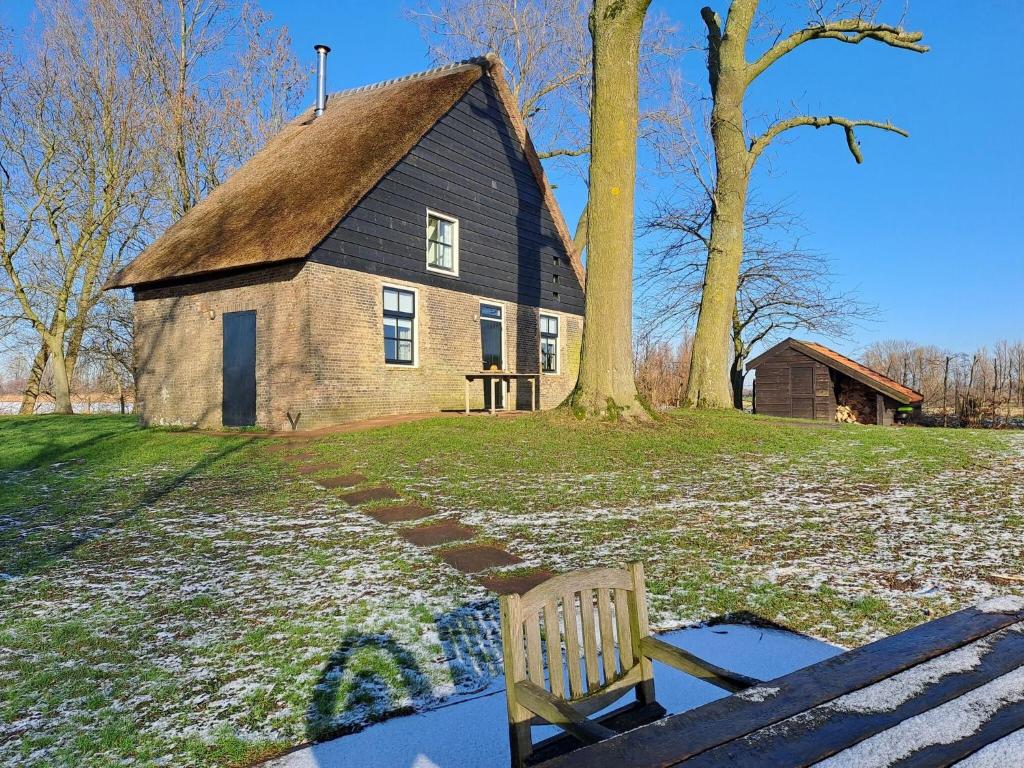 Hooge ZwaluwePicturesque Holiday Home in Drimmelen with Garden的树屋前的长凳