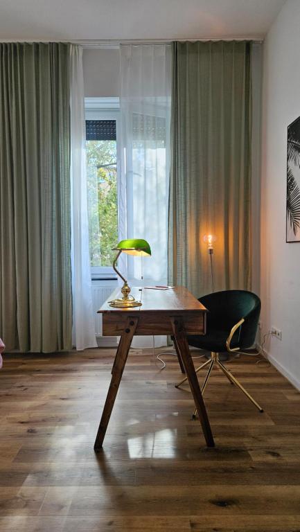 普福尔茨海姆Innenstadt Studio的一张桌子,里面配有一盏灯和一把椅子