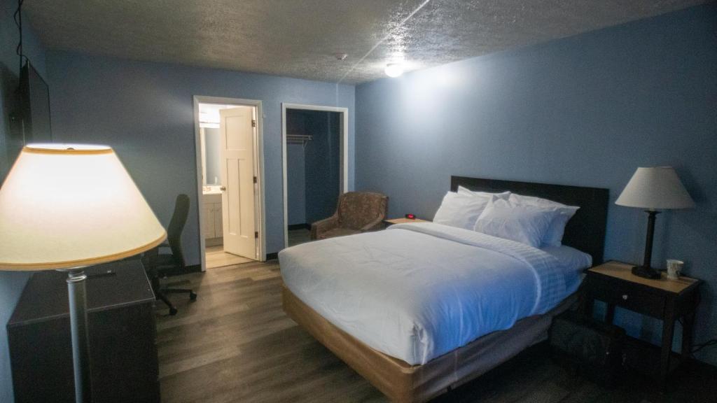 普兰菲尔德Ashley Motel的一间卧室配有一张蓝色墙壁的床