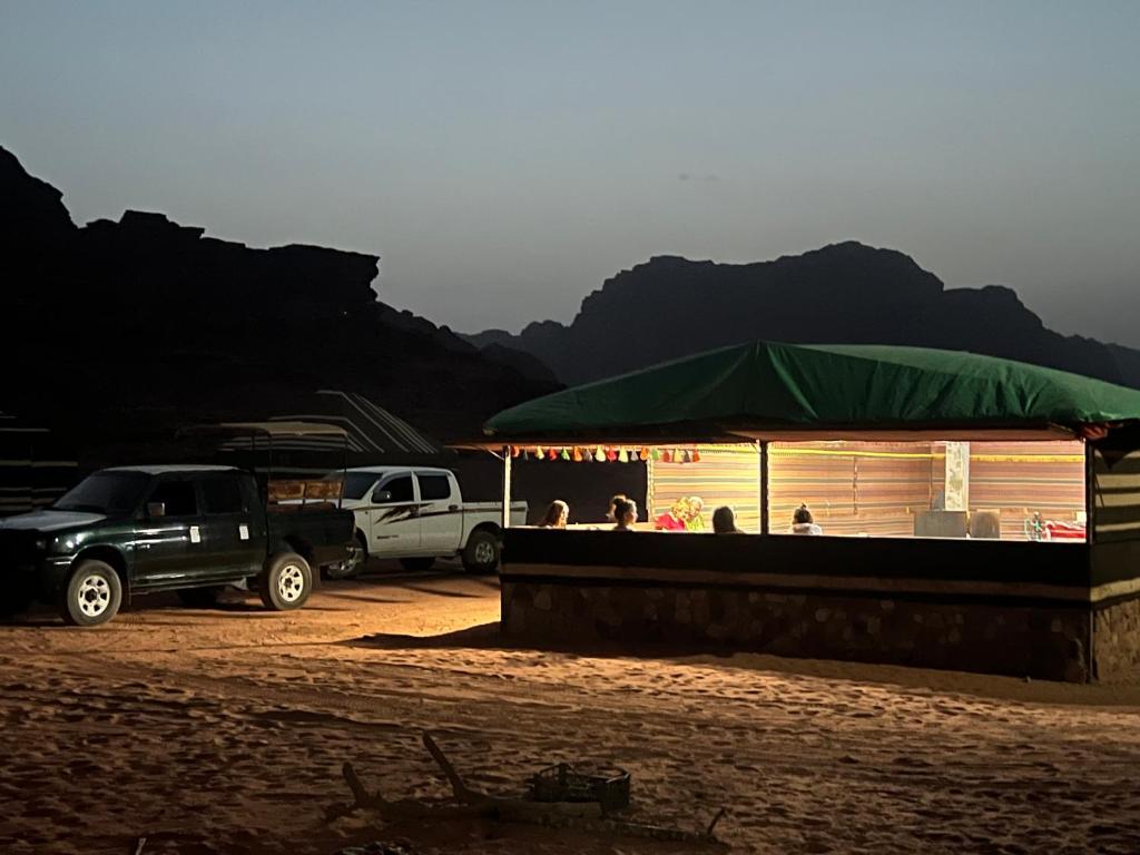 瓦迪拉姆Wadi rum Bedouin Experience的停泊在一座有帐篷的建筑旁边的卡车