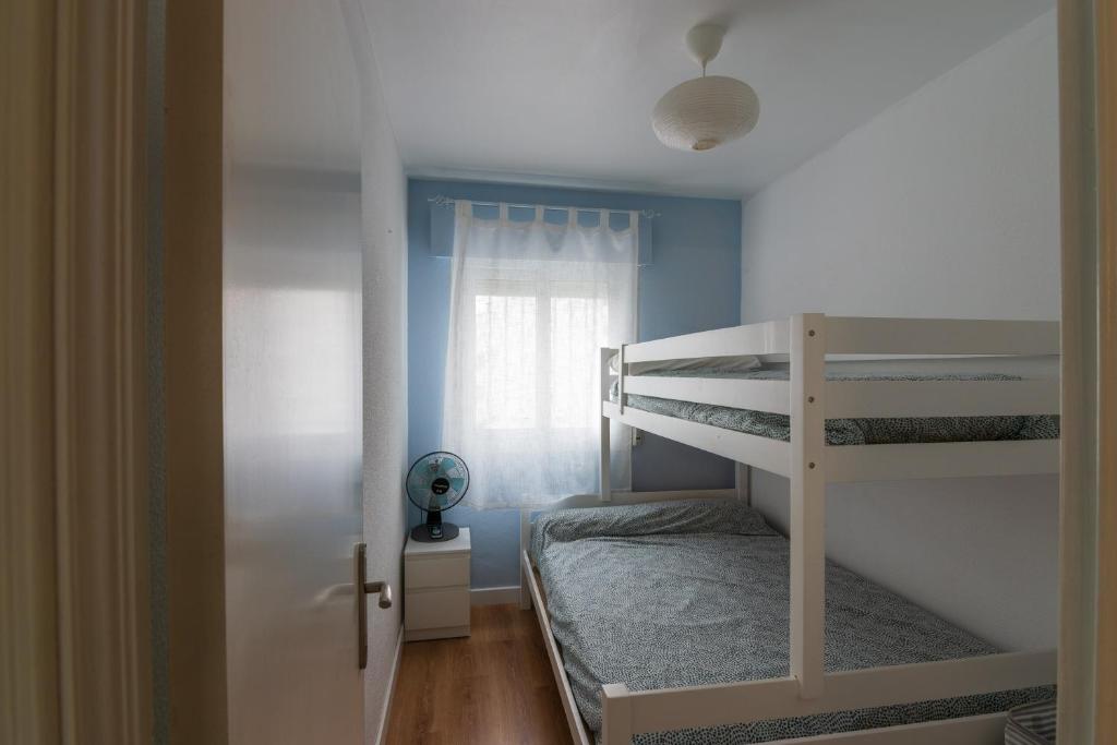 埃尔波提尔Cosy 2BR flat in Nuevo Portil city centre的一间小卧室,配有双层床和窗户