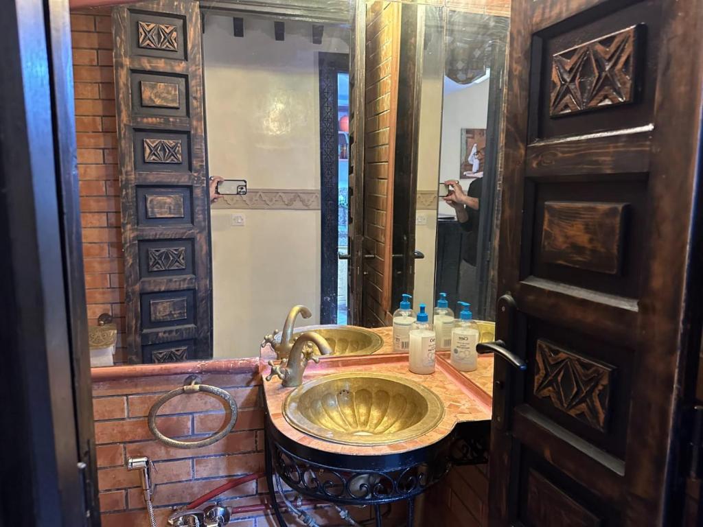 马拉喀什RIAD Anis的浴室设有金色水槽和镜子