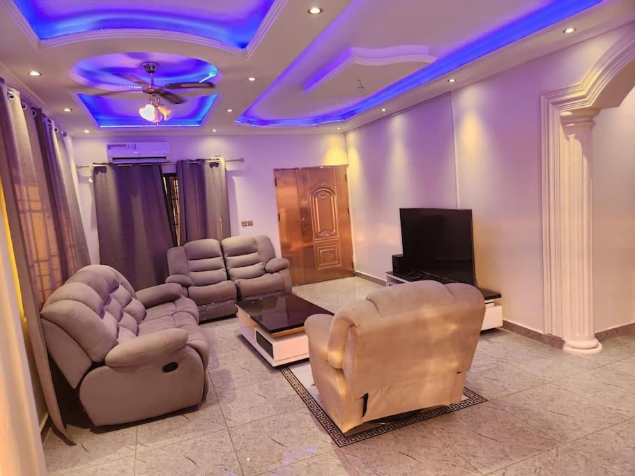 弗里敦Medi Square Lodge的客厅配有椅子和平面电视