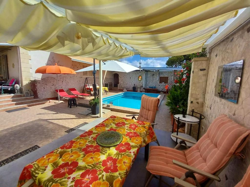 切萨雷奥港2 bedrooms property with shared pool at Porto Cesareo 1 km away from the beach的一个带桌椅的庭院和一个游泳池