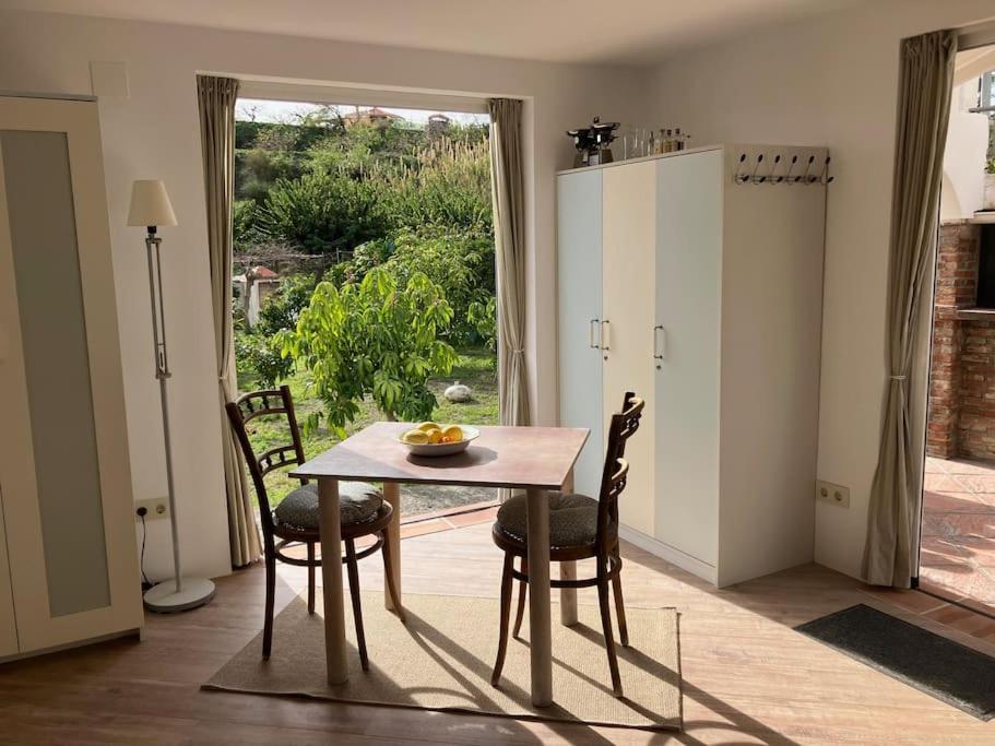 萨各夫雷纳La Peñita - sunny guesthouse with private pool and garden的一间带桌椅和窗户的用餐室