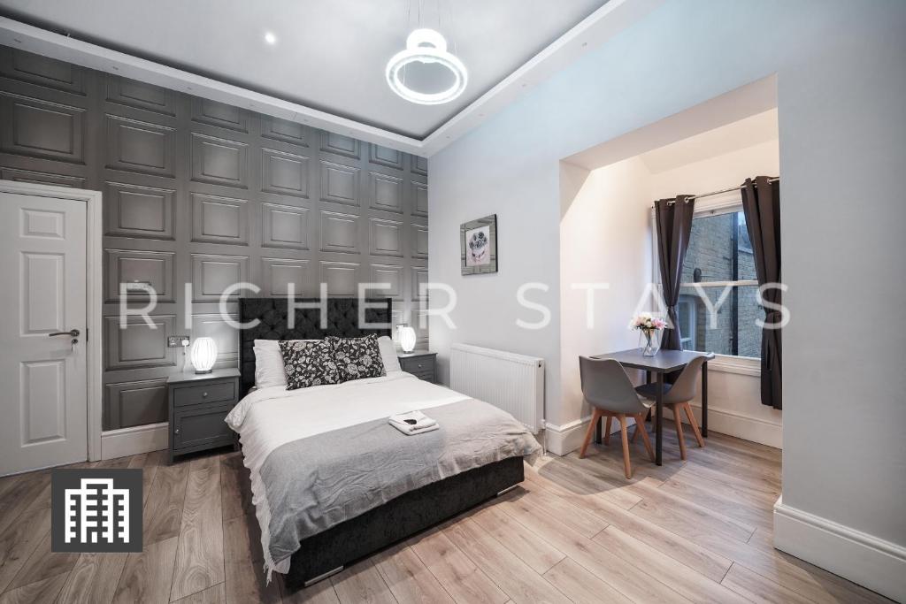 伦敦Hackney Suites - En-suite rooms & amenities的一间卧室配有一张床和一张书桌