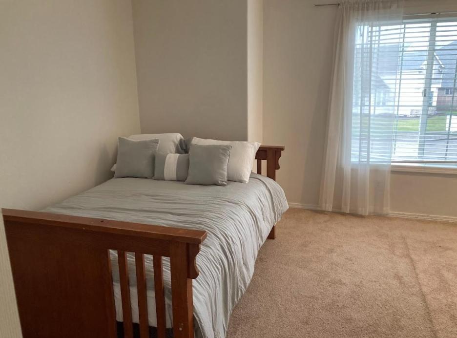 希尔斯伯勒Home sweet home的卧室配有带枕头的床铺和窗户。