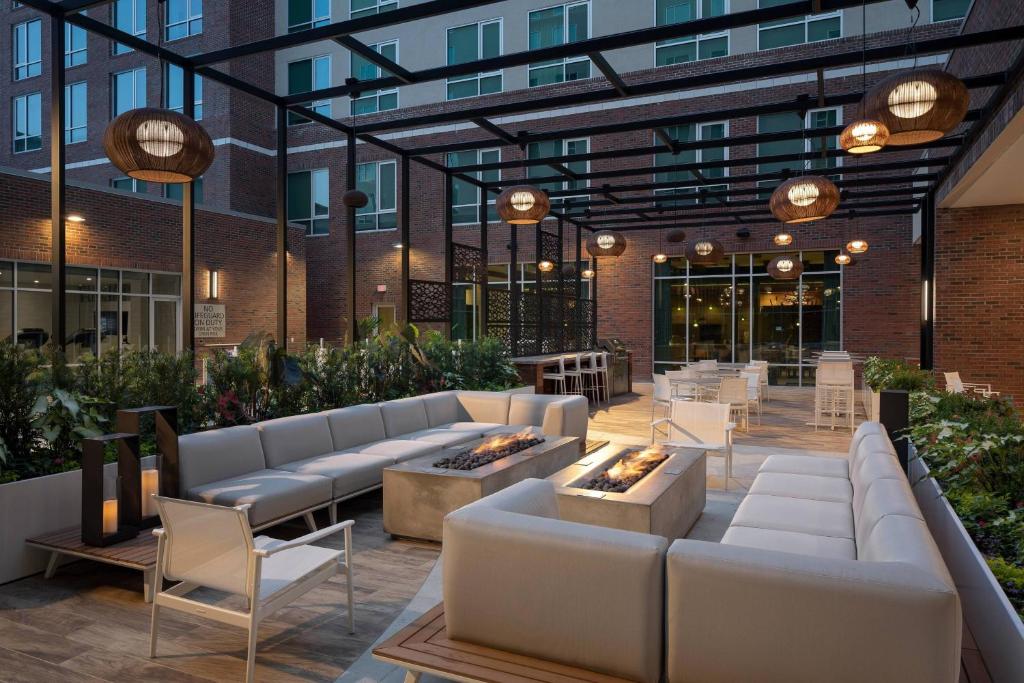 格林维尔SpringHill Suites by Marriott Greenville Downtown的一个带沙发和桌子的庭院和一座建筑