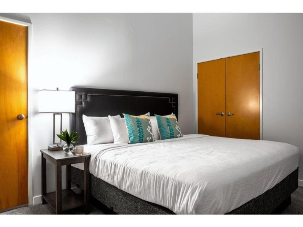 印第安纳波利斯Modern Apartment Close To Everything CozySuites的一间卧室配有一张大床和一个木制橱柜