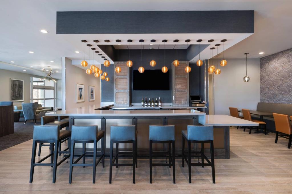 欧文TownePlace Suites by Marriott Dallas DFW Airport North/Irving的厨房以及带蓝椅酒吧的用餐室