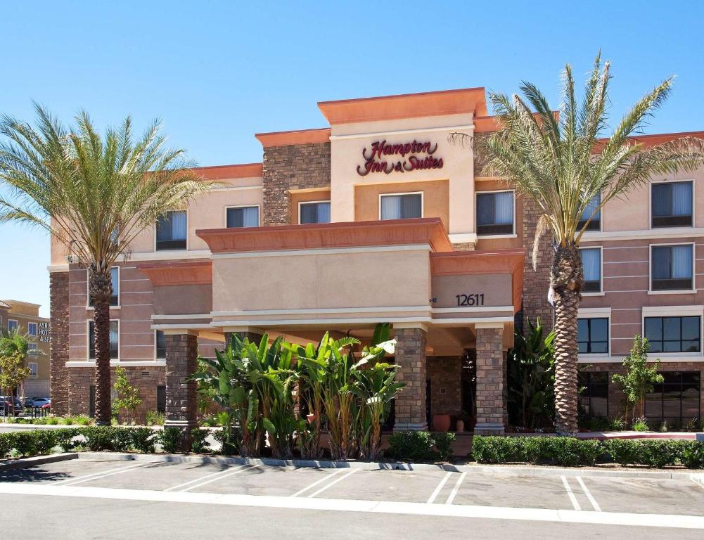 莫雷诺谷Hampton Inn & Suites Moreno Valley的停车场内棕榈树的酒店