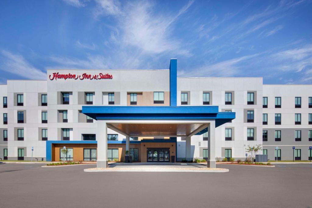 比洛克西Hampton Inn & Suites D'Iberville Biloxi的一座白色的大建筑,上面有红色的标志